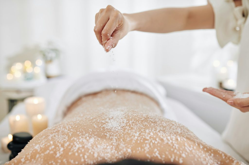 Beautician applying salt scrub