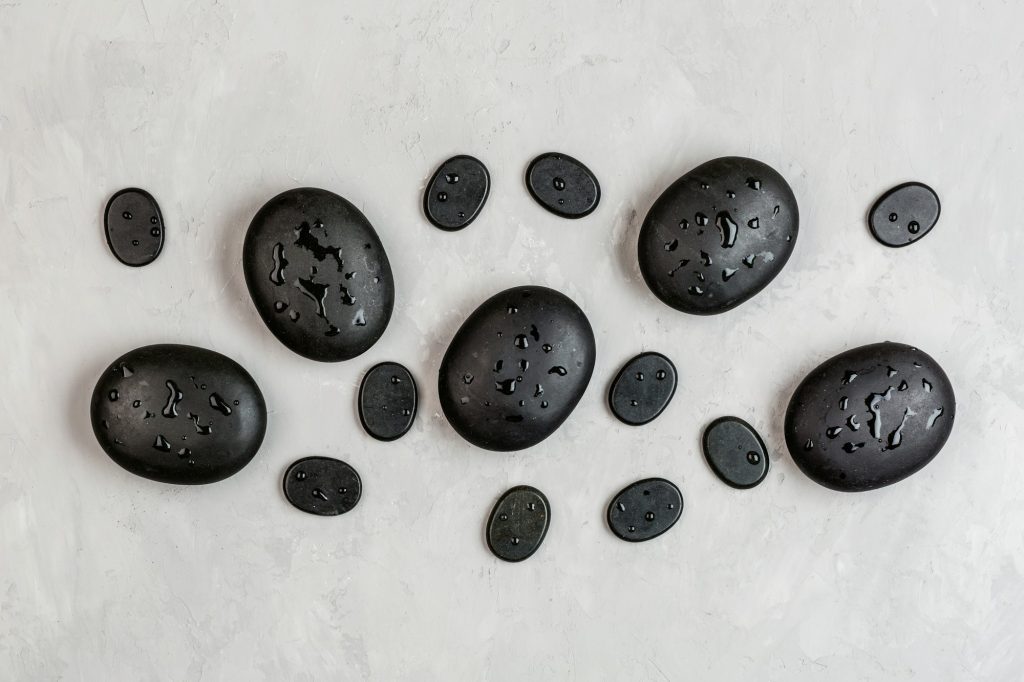 Flat lay of hot spa stones for massage treatment. Top view overhead